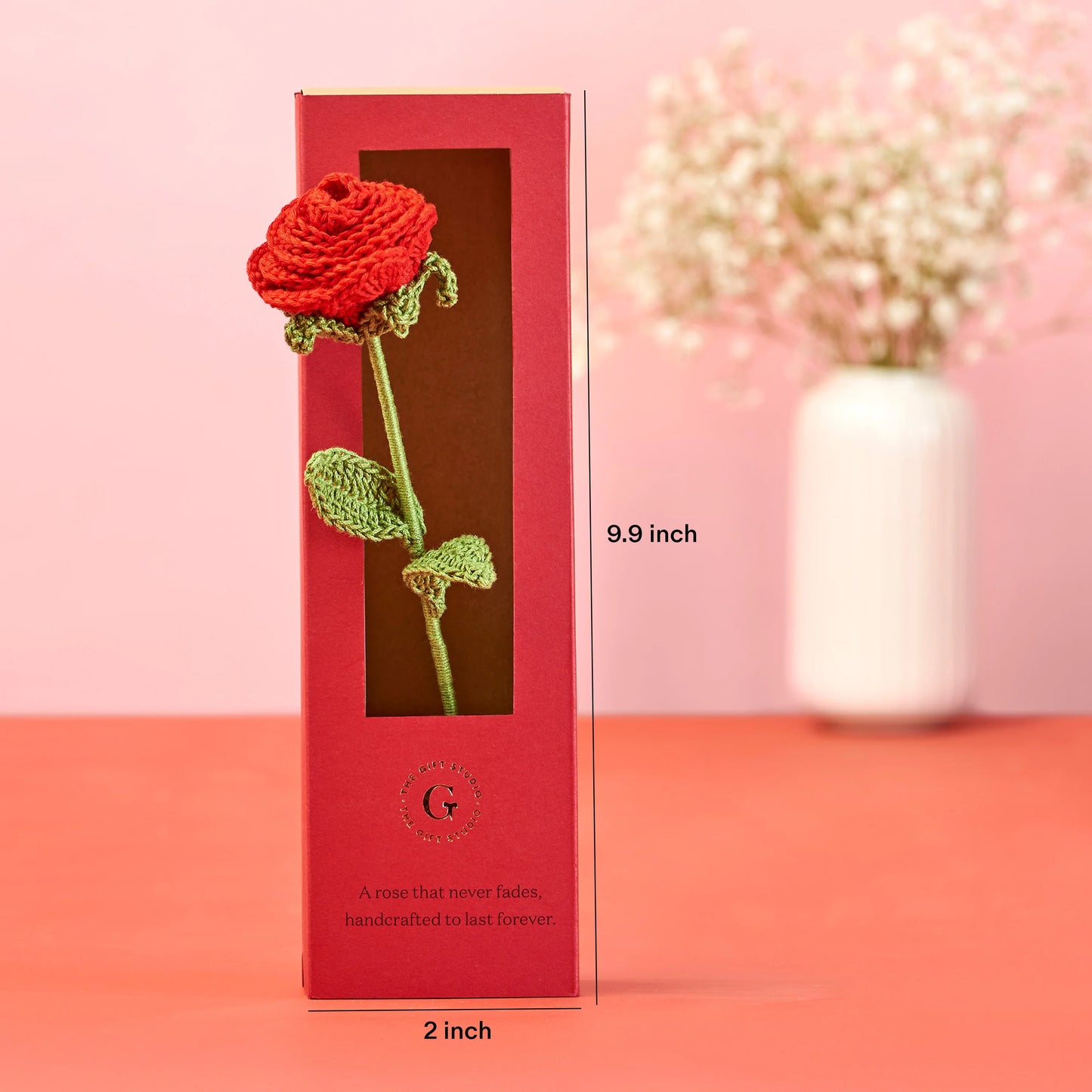 Handcrafted red crochet rose gift in tall red box with window, pink background