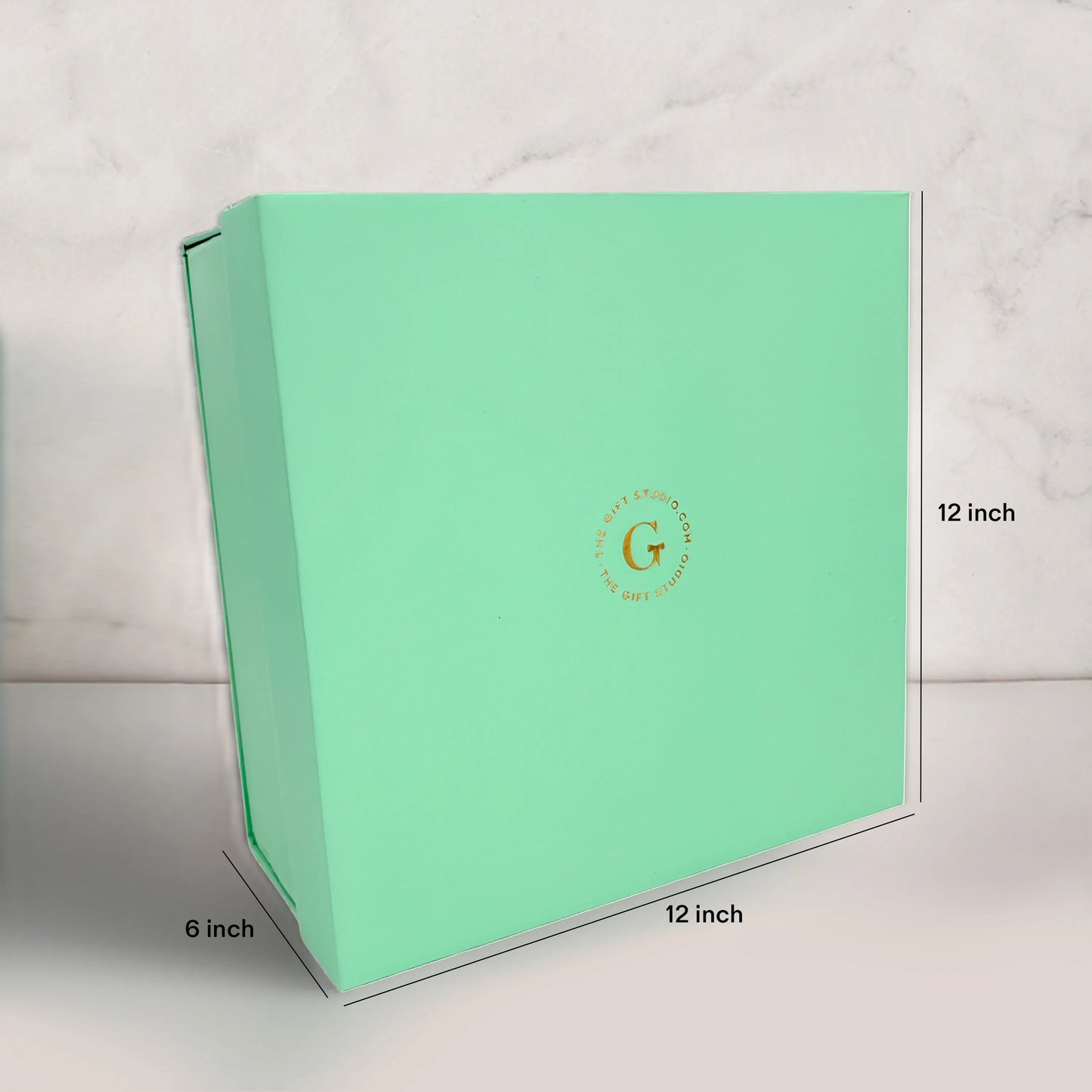 Medium mint green gift box, 12x12x6 inches, with gold detailing on marble background