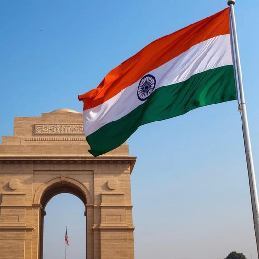 Indian flag waving in front of India Gate monument under clear blue sky