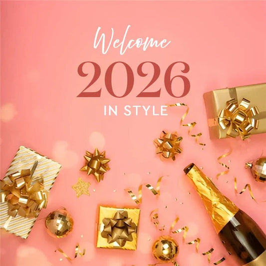 Gold-wrapped gift boxes, champagne bottle, and party decor on pink background for New Year 2026 celebration.