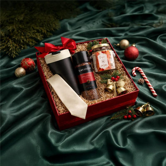 Festive gift hamper with coffee, snack jar, travel mug, tie, and Christmas decorations