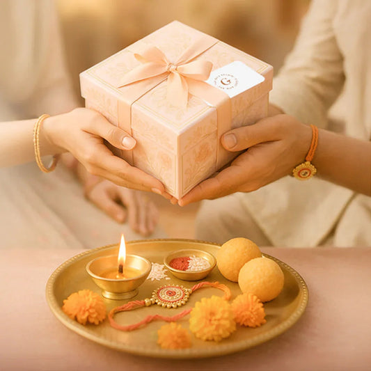 Hands exchanging a gift box with ribbon, festive sweets and decor on a tray, Raksha Bandhan theme