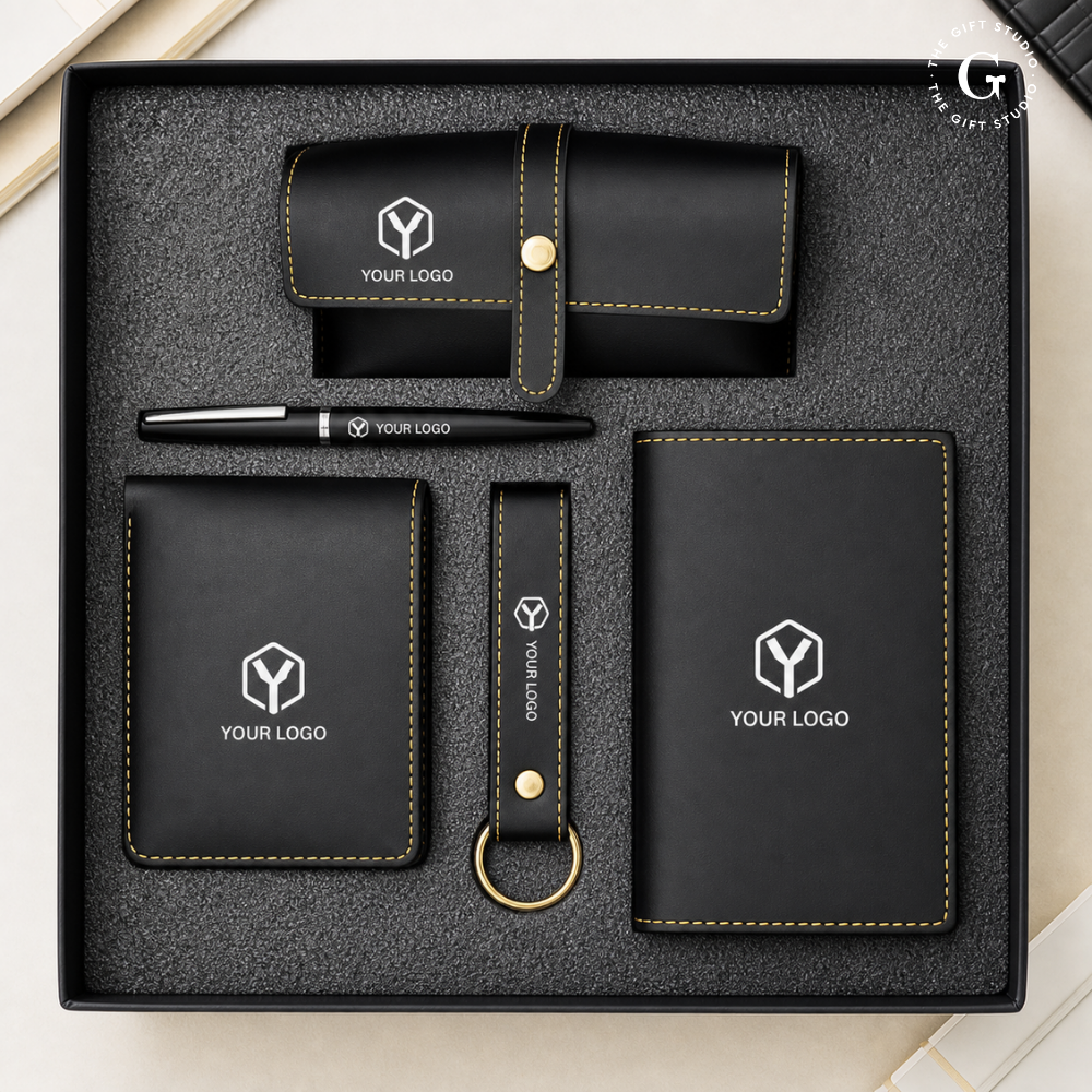Black branded stationery set with metal pen, eyewear case, wallet, keychain and passport cover with TGS branding.