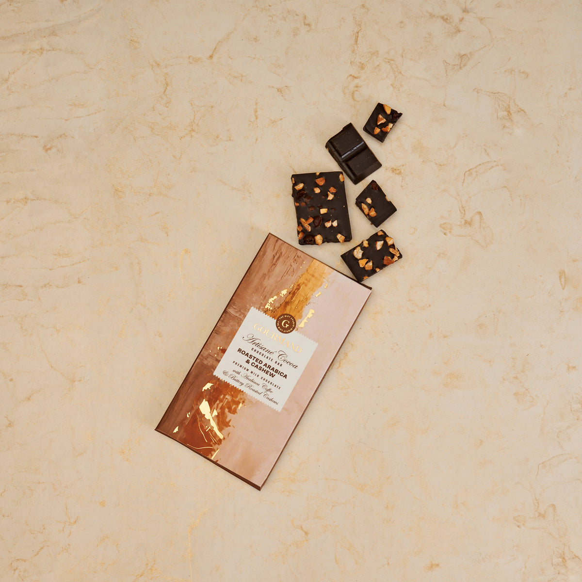 The Gift Studio Roasted Arabica & Cashew chocolate bar and pieces on a neutral background