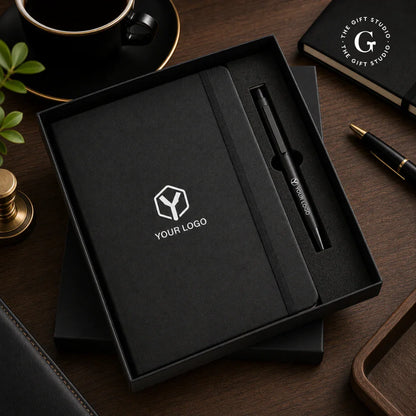 TGS Black notebook with pen and logo in a box on a desk 