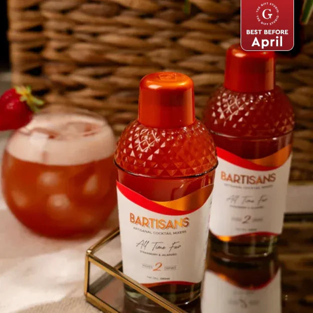 Bartisans cocktail mixers with glass of strawberry drink on table, premium gift option