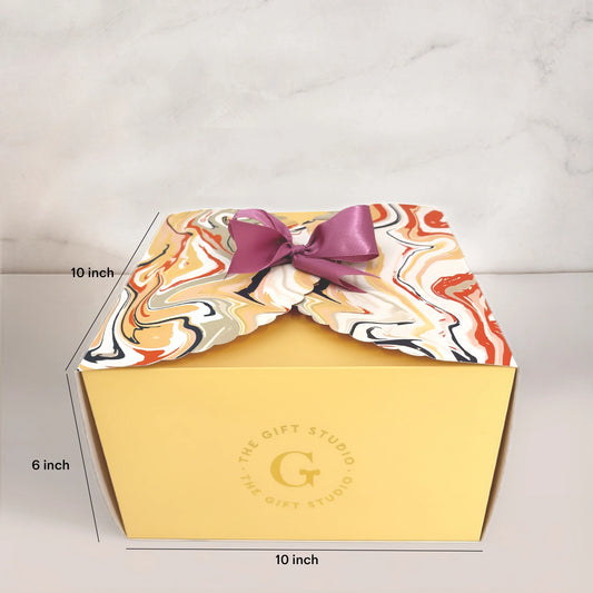 Yellow gift box with marbled lid, purple ribbon, and dimensions marked 10x10x6 inches
