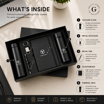 TGS black office gift set with branded items on a wooden surface like pen, bottle, flask, keychain and diary.