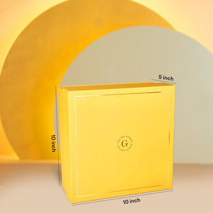 A yellow square Diwali hamper box by The Gift Studio with dimensions 10x10x5 inches.