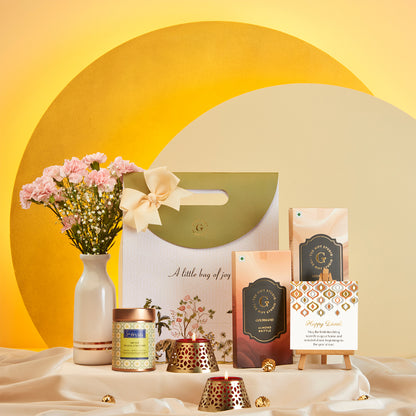 Diwali Treat Bag gift hamper from The Gift Studio with sweets, candles, and flowers.