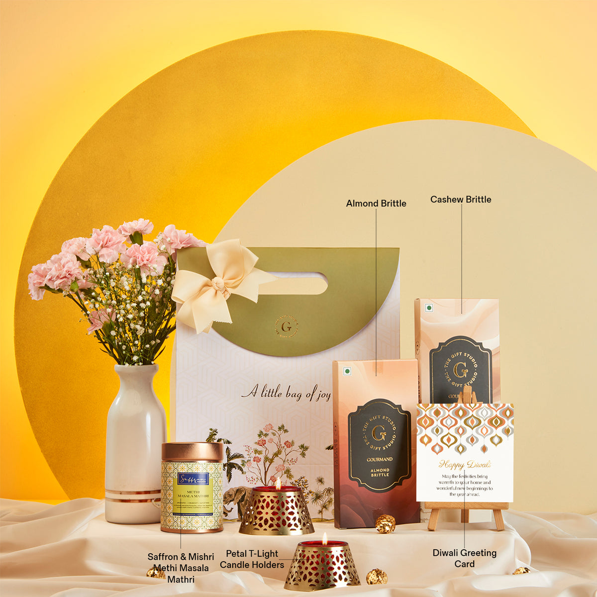 Diwali Treat Bag gift hamper from The Gift Studio with sweets, candles, and flowers.