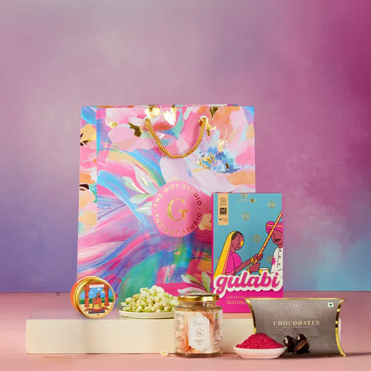 Colorful gift hamper with sweets, box of chocolates, and scented items for Holi celebration