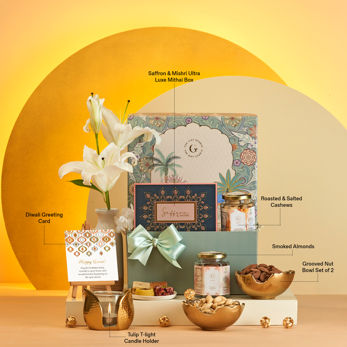 The Diwali Soirée Hamper by The Gift Studio featuring mithai, nuts, and a candle holder.